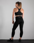 reyllen ladies racerback train top with built in bra black back view worn with leggings