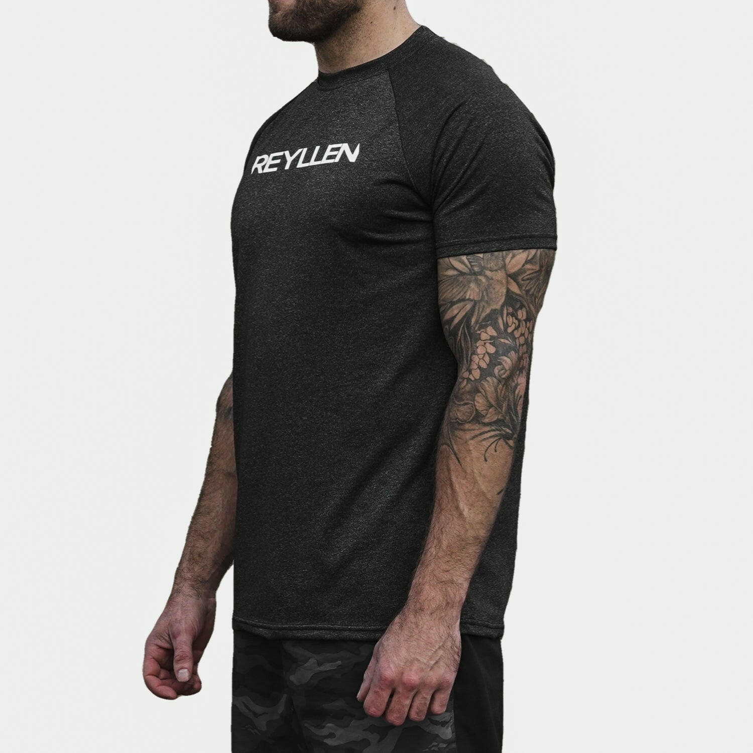 Reyllen m1 t-shirt. Polyester raglan style charcoal black mens modelled by man side view