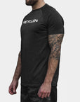 Reyllen m1 t-shirt. Polyester raglan style charcoal black mens modelled by man side view